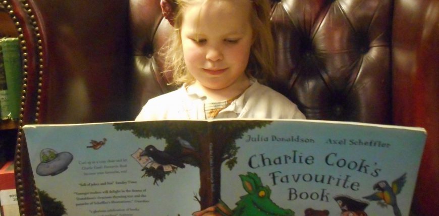 Girl sitting in library reading a book